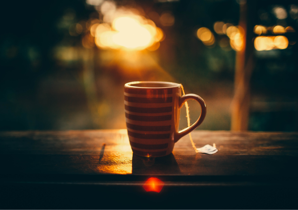 A cup of herbal tea with soft lights behind it.