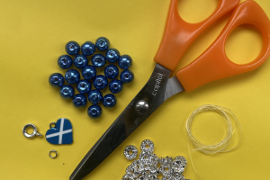 Beads, a charm, elastic and scissors.